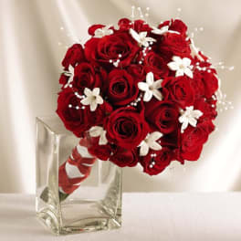 Red rose bouquet with white accents in a clear square vase