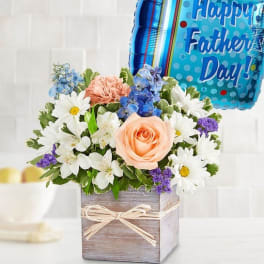 Mixed flower arrangement in a wooden box with a Father's Day balloon