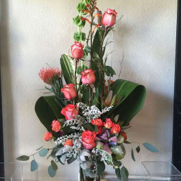 Tall floral arrangement with pink roses in a glass vase