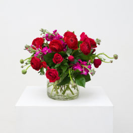 Red and pink flower bouquet in a clear glass vase
