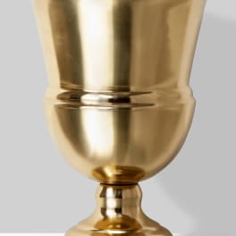 Gold metal urn vase on a plain background