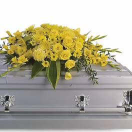 Yellow floral spray arranged on a silver casket