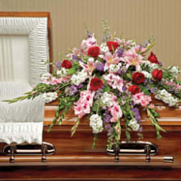 Casket spray with red, pink, white, and purple flowers