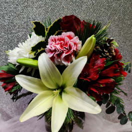 Bouquet of lilies, carnations, roses, and daisies in a glass vase