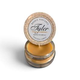 Small amber candle in a glass jar with a patterned lid