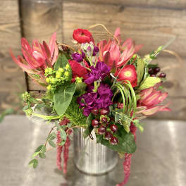 Pink and purple floral arrangement in a metal vase