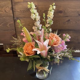 Pink and peach floral arrangement in a glass vase