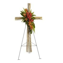 Standing floral cross with roses and greenery on a bamboo easel