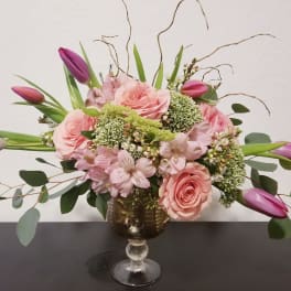 Pink roses and purple tulips in a gold goblet vase