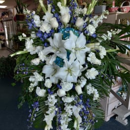 Large white and blue funeral spray with lilies and orchids