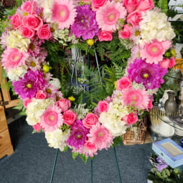 Heart-shaped floral wreath with pink roses, gerbera daisies, and white blooms