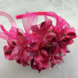 Pink floral headpiece with ribbon loops and rhinestone accents