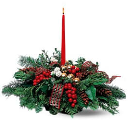 Holiday centerpiece with a red taper candle and evergreen arrangement