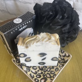 Soap bars and a black decorative flower on patterned trays