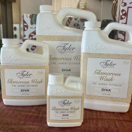 Four bottles of Tyler Glamorous Wash laundry detergent on a table