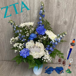 Blue and white floral arrangement in a vase with a crown accent