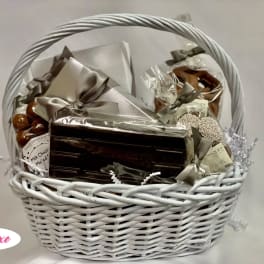 White wicker basket filled with wrapped chocolates and sweets