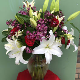 Bouquet of white lilies and red roses in a glass vase