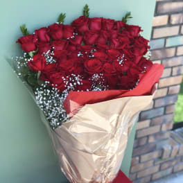 Bouquet of red roses with white baby's breath in brown and red wrapping