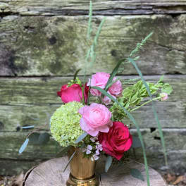 Pink and red roses with green hydrangea in a gold vase