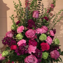 Pink and purple floral arrangement in a white vase