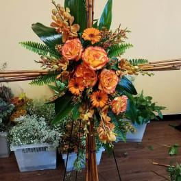 Tall floral arrangement with orange roses and gerbera daisies on bamboo supports