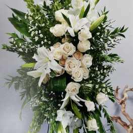 Tall white floral spray with roses and lilies on a stand