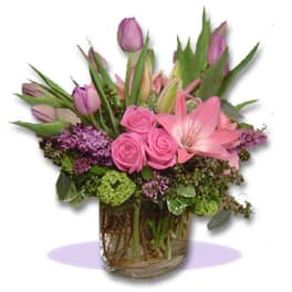 Pink roses and lilies in a clear glass vase