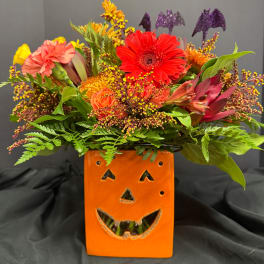 Autumn flower arrangement in an orange jack-o'-lantern container
