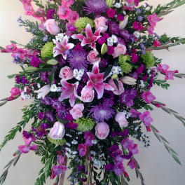 Large standing spray of pink and purple flowers on an easel