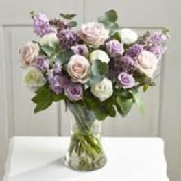 Bouquet of pale pink and lavender flowers in a clear glass vase