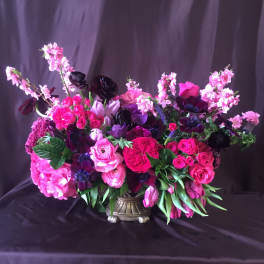 Large pink and purple floral arrangement in a decorative vase