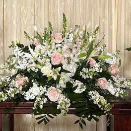 Large white and blush floral casket spray with lilies and roses