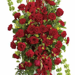 Tall red rose and carnation standing spray with green accents