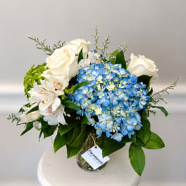 Blue hydrangeas and white roses in a glass vase
