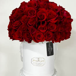 Red rose bouquet in a white hat box with ribbon