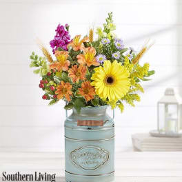 Mixed bouquet in a blue metal milk can vase