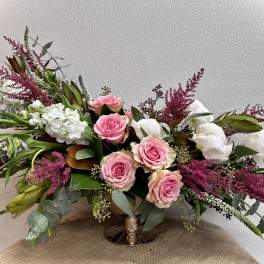 Pink roses and white blooms in a low gold vase arrangement