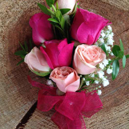 Small bouquet of pink and blush roses with a magenta ribbon