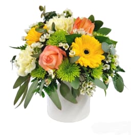 Mixed bouquet in a white vase with yellow, peach, and white flowers