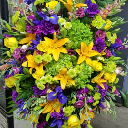 Large standing spray with yellow lilies, purple flowers, and green hydrangeas