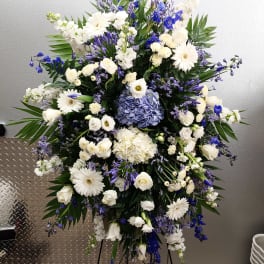Large white and blue floral standing spray on an easel