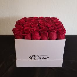 Box of red roses in a white square container