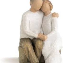 Wooden figurine of a seated couple embracing