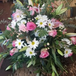 Pink roses and white daisies in a lush bouquet with lily buds