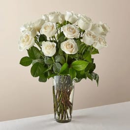 White roses arranged in a clear glass vase
