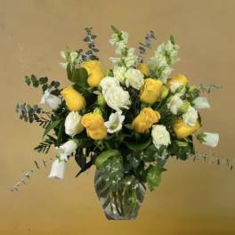 Yellow and white roses in a clear glass vase