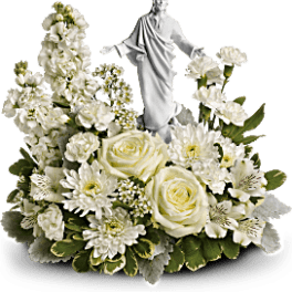 White floral arrangement with a small religious statue centerpiece