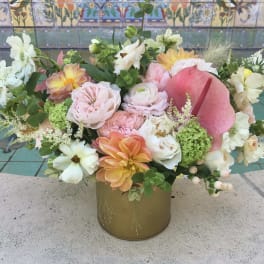 Mixed pastel flower arrangement in a gold vase