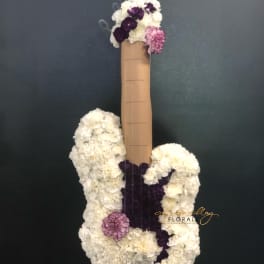White and purple floral arrangement shaped like a guitar